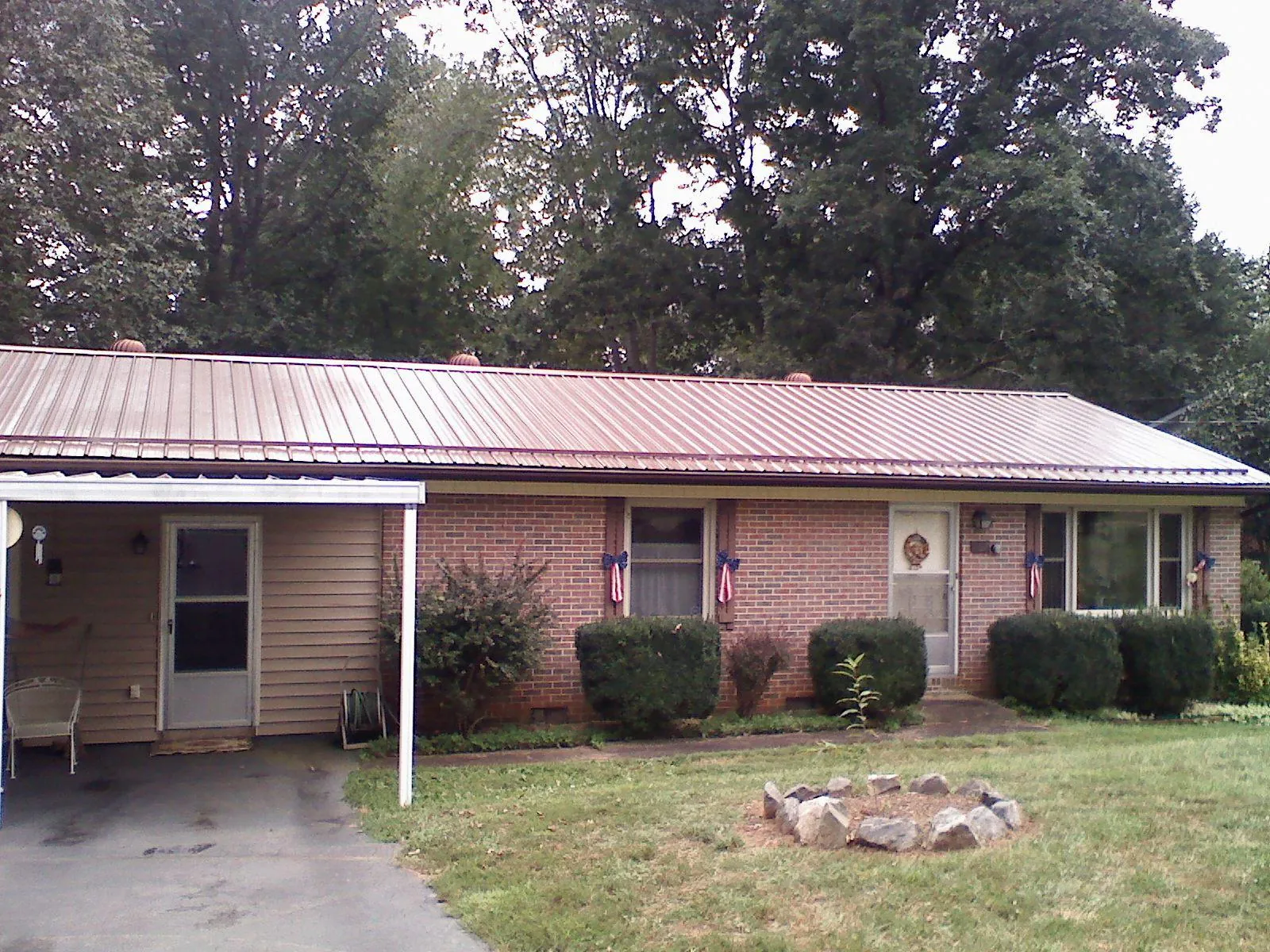 Bronze metal roof and carport on a brick ranch home — Roof Repair work by our crew in Lakebay